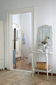 Ornate, antique, shabby chic washstand next to doorway leading to country house bedroom