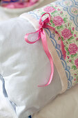 Romantic pink and pale blue pillow with pattern of roses and bow