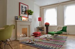 Grüner Designer Sessel mit passendem Fussschemel auf Teppich im Kaminzimmer