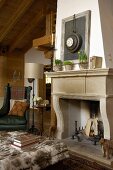 Sitting area with antiques in front of an fireplace with an old stone surround in a renovated country home