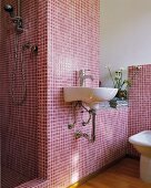 Weißes Waschbecken an Wand mit weinroten Mosaikfliesen und offener Duschbereich in Designerbad mit Retroflair