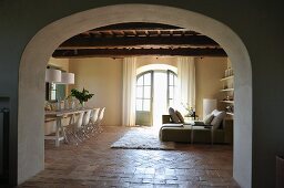 Rustic country house with designer furnishings - view through wide arched doorway into open-plan living and dining room