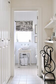 Dressing room in hallway with fitted wardrobe and ornate towel rail; view of washstand in ensuite bathroom