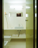 View of bright, simple designer bathroom through open door painted lime green