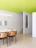 Esszimmer mit weissen Wänden und grüner abgehängter Decke