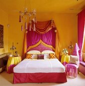 Orientalisch angehauchtes Schlafzimmer in knalligen Bonbonfarben mit Baldachinbett