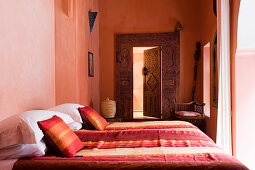 Marokkanisches Schlafzimmer mit Doppelbett in verschiedenen Rottönen