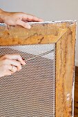 A wire mesh being fitted into a picture frame