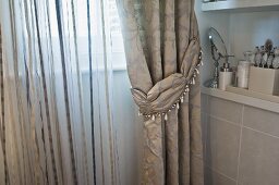 Elegant brocade curtain and striped translucent curtain at bathroom window