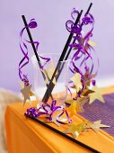 Halloween decorations (black straws with purple ribbon and gold stars)
