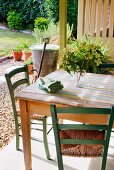 Rustic table and chairs on terrace with view of garden