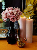 Flowers, candles and pistachios on a table