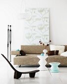 Bodennaher Stuhl im Ethnostil vor modernen Beistelltischen und Sofa