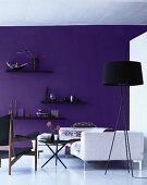 Showroom - black standard lamp and white sofa in front of purple-painted wall