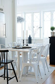 Kitchen table and white, retro-style metal chairs in open-plan interior