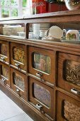 Breakfast crockery in traditional kitchen dresser with wood and glass drawer fronts