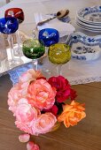 Posy of roses, lead crystal glasses and blue and white crockery on wooden table