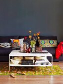 Sitzecke im Wohnzimmer im Stilmix mit Sofa, Dekokissen, gemustertem Teppich & Couchtisch