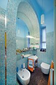Modernes Bad mit orientalischem Flair - Mosaikfliesen im Rundbogen umfasst Spiegel und Sanitärobjekte