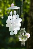 Wind chime made from Capiz shells and glass bead pendant lantern in garden