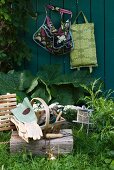 Basket of gardening utensils on wooden block in garden