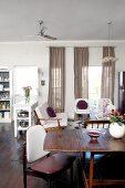 Open-plan living-dining room with white-upholstered seating and ceiling fan