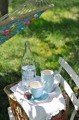 Crockery placed on picnic basket on garden chair