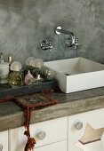 Washstand with square basin against grey partition