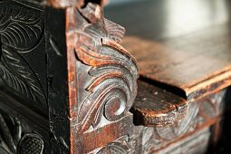 Holzschnitzerei an einer antiken Sitzbank
