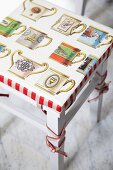 Cushion with pattern of vintage mugs on kitchen stool