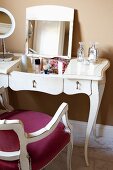 Vintage-look, white dressing table with fold-up mirror, curved legs and matching chair with dark red seat cushions