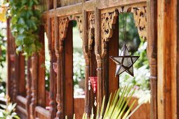 Three-dimensional star hanging from carved wooden panel