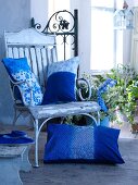 Blue and white decorative pillows on a wooden chair