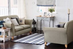 Blue and white accents in inviting seating area with two sofas and small vintage desk