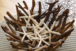 Dried starfish in original bowl of woven roots on wicker mat