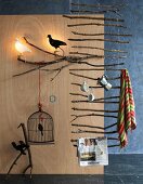 Leiterförmige Aufhängung aus Ästen & verschiedene Dekoobjekte mit Vogelmotiven