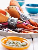 Napkins in ornate napkin rings and cutlery on tray