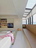 Einbauregal mit integriertem Fernseher in modernem Wohnraum mit erkerartigem Anbau und umlaufendem Fensterband