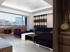Seating upholstered in violet and a coffee table in a designer living room with a panorama window