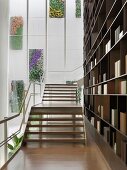 Staircase in modern building with large bookcase alongside of it