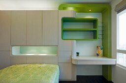 Futuristic wall unit with recessed shelves and desk and green accents