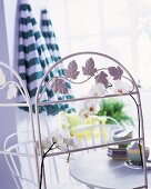 White metal screen decorated with flowers in front of a patio set