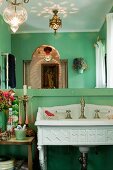 Waschbecken in antikem Stil im Badezimmer mit grüner Wand