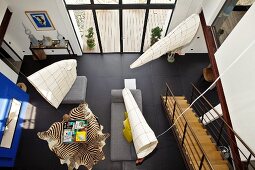 Hängende Objekte über dem Wohnbereich eines modern eingerichteten Hauses mit schwarzem Fliesenboden
