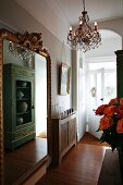 French cabinet reflected in gilt-framed mirror in hallway with bamboo parquet floor