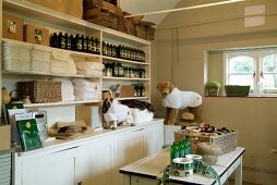 White, country-house-style dresser holding many bottles and stacks of medical dressings for dogs modelled on soft toys