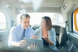 Pair talking business with a tablet computer in a car
