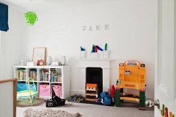 White child's bedroom with half-height shelving and fireplace