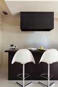 Minimalist, black kitchen counter with white bar stools