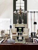 Black and white colour scheme and eclectic furnishings in traditional living room with open fireplace and large, brown leather couch